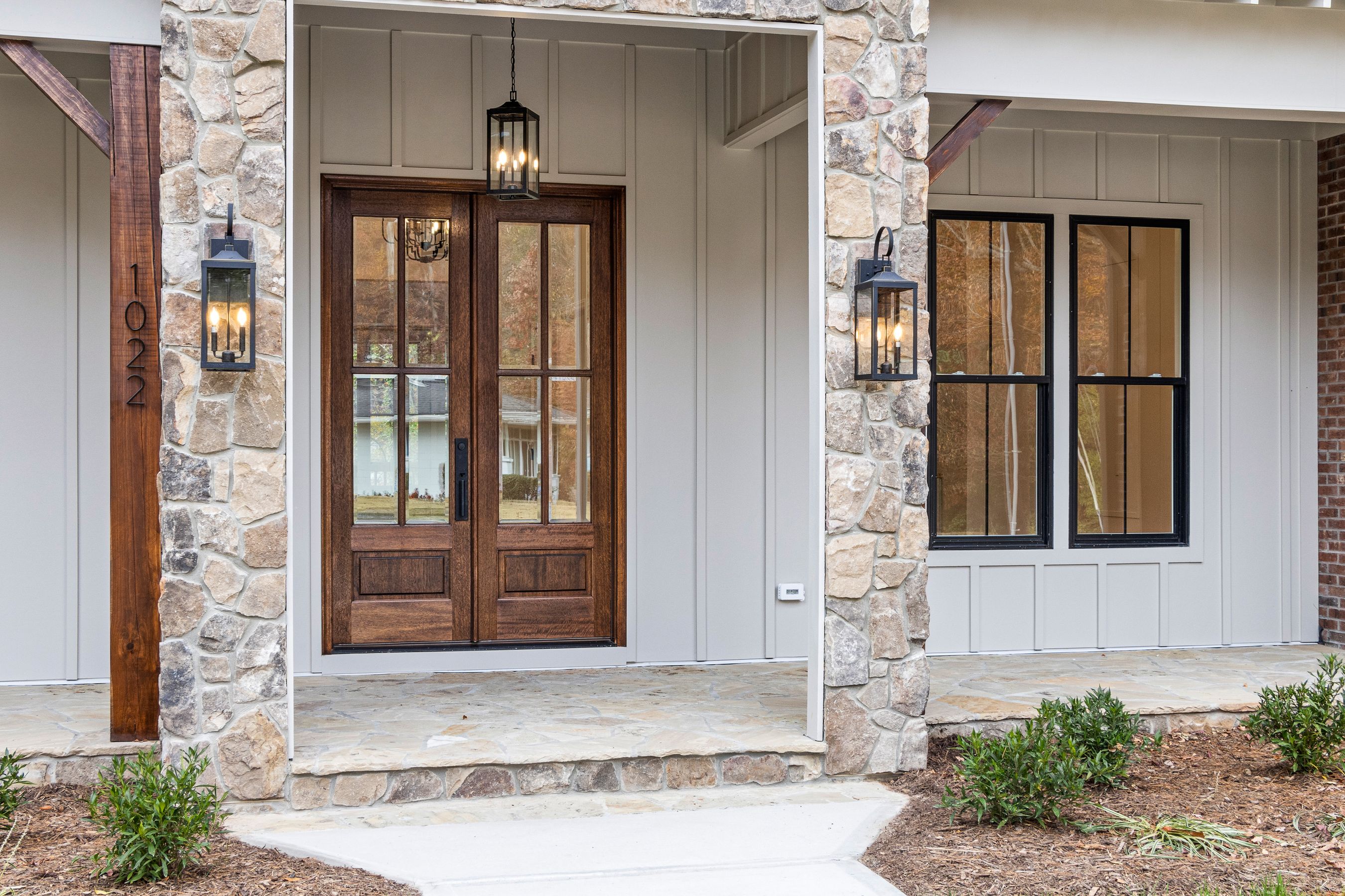 Finished stone front entrance with wooden double doors