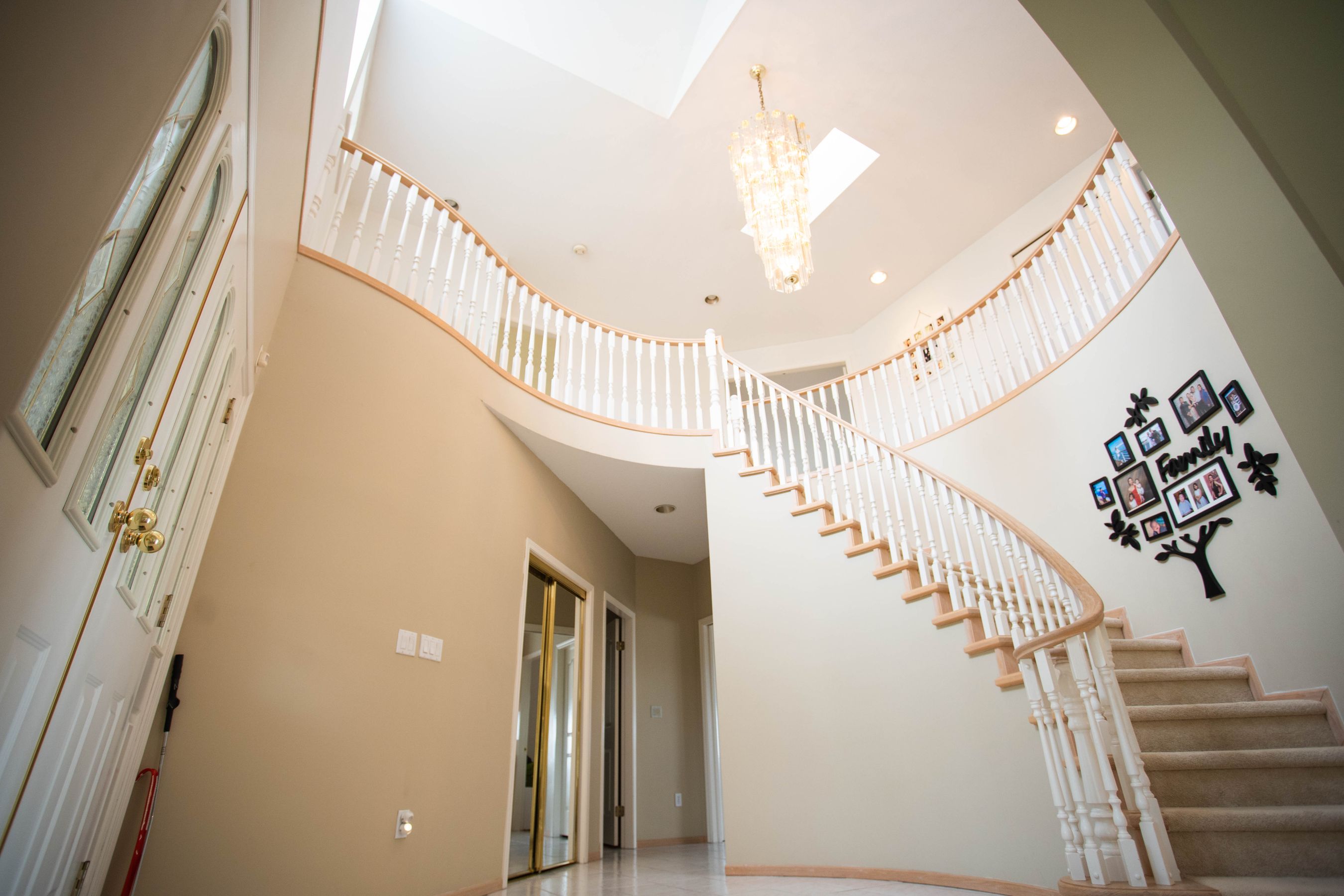 Finished foyer with a curved staircase and chandelier
