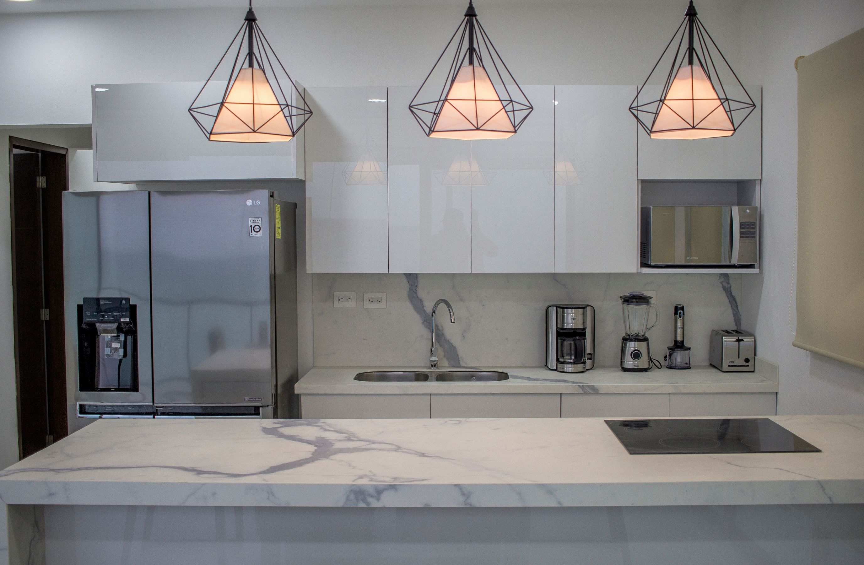 Finished kitchen with a marble island and pendant lights