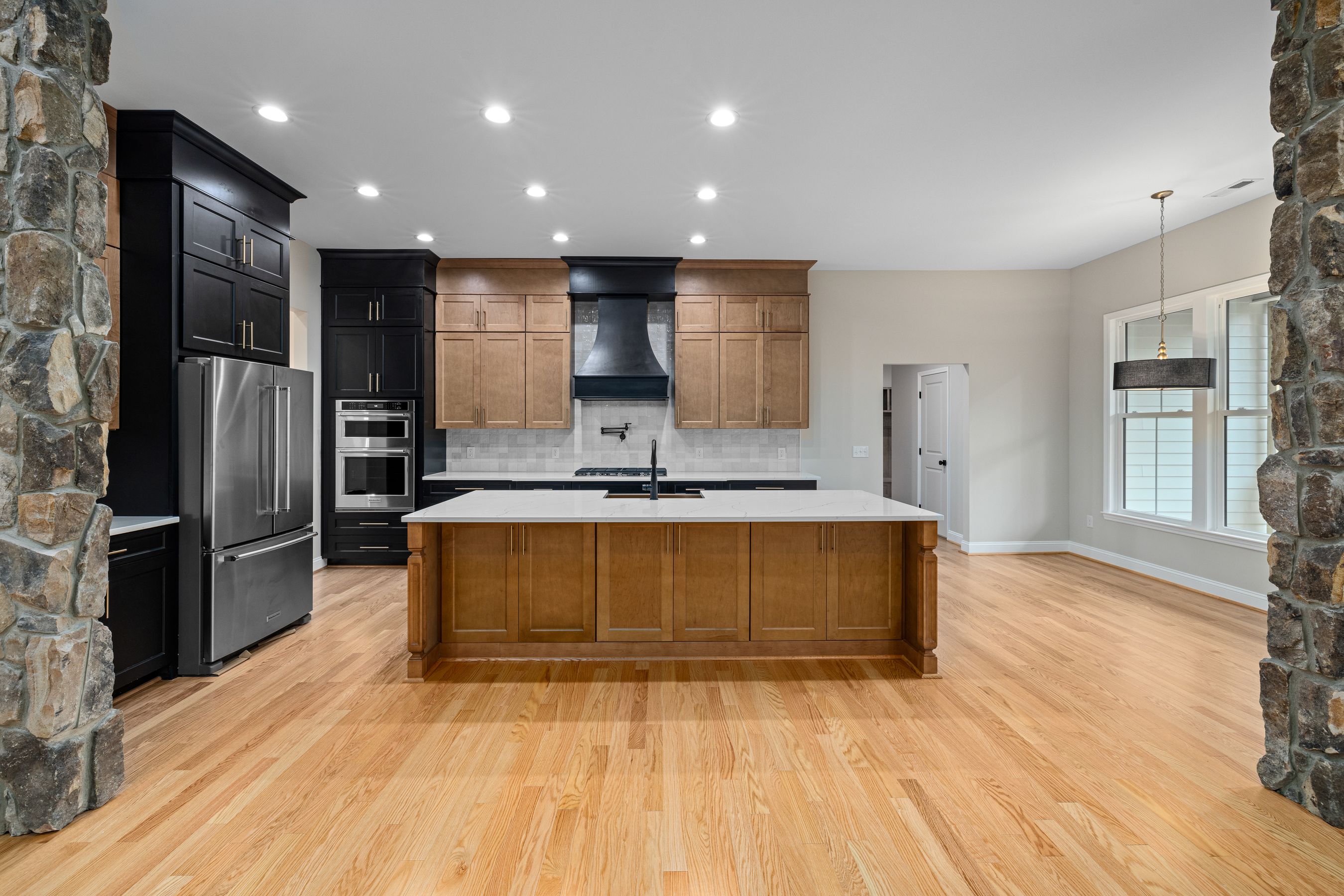 Finished kitchen with an oak island and black cabinets