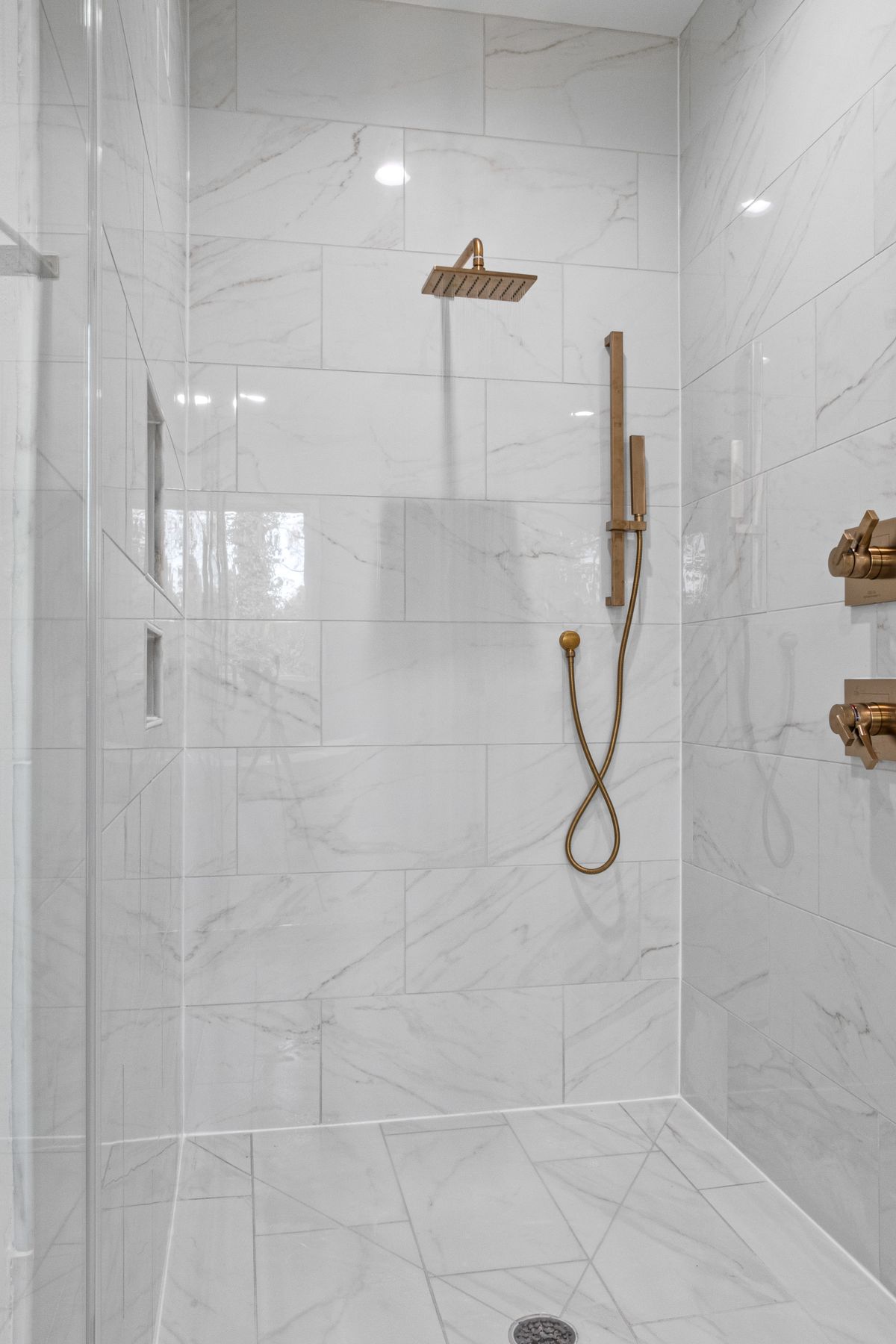Finished marble shower with brass fixtures